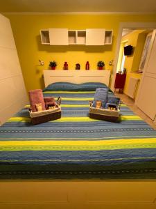 - une chambre avec un lit et 2 chaises dans l'établissement Cà di Dome Appartamento vista mare, à San Bernardino