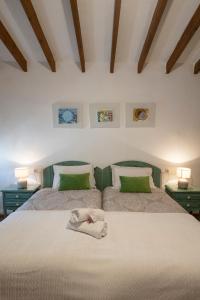 1 Schlafzimmer mit 2 Betten und grünen Kissen in der Unterkunft Casa rural La bodega in Alicante