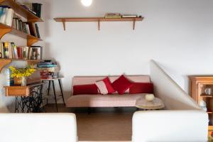 Casa rural La bodega في أليكانتي: غرفة معيشة مع أريكة مع وسائد حمراء