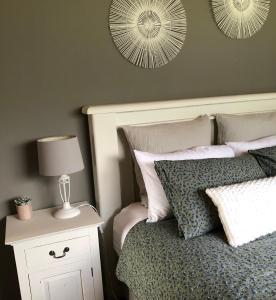 a bedroom with a bed with a lamp and two mirrors at Cosy Country Stay B&B in Matamata