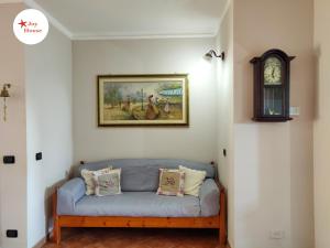 Joy House في بورتو توريس: أريكة زرقاء في غرفة بها ساعة على الحائط