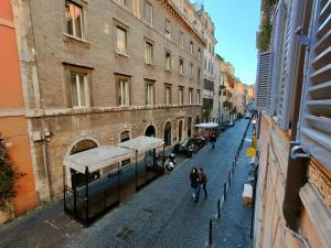 a street with a building and people walking down the street at Maison Carolina in Rome