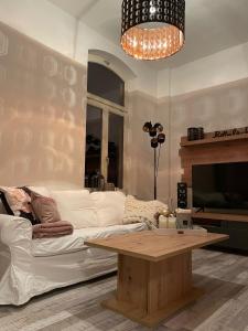 a living room with a white couch and a coffee table at Apartment zur Wiege Anhalts in Ballenstedt