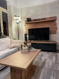 a living room with a table and a flat screen tv at Apartment zur Wiege Anhalts in Ballenstedt