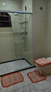 y baño con ducha, aseo y esterillas. en Arraial do Cabo - suite, en Arraial do Cabo