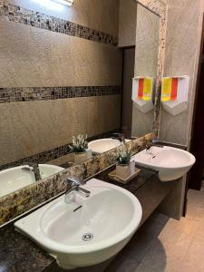 a bathroom with two sinks and a mirror at Nova Hotel Miri in Miri