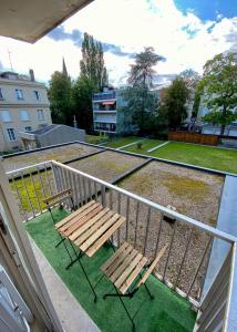 un balcón con 2 sillas de madera y una valla en Studio bohème - Centre - Proche gare en Mulhouse