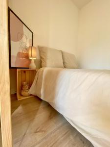um quarto com uma cama com uma colcha branca em Studio bohème - Centre - Proche gare em Mulhouse