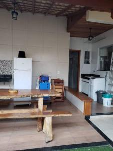 a patio with a table and a kitchen with appliances at Linda casa 3 quartos Castelhanos ES in Anchieta