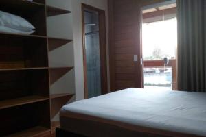 a bedroom with a bed and a large window at Linda casa 3 quartos Castelhanos ES in Anchieta