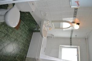 a bathroom with a toilet and a sink and a mirror at Family Hotel Magnolia in Balchik