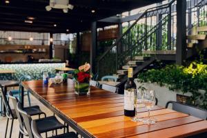 SAVV HOTEL في جورج تاون: طاولة خشبية مع زجاجتين من النبيذ والاكواب