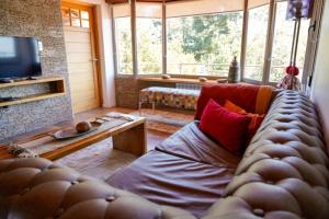 un soggiorno con divano e TV di Posada La Escondida a Villa Pehuenia
