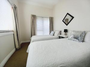 a bedroom with two beds and a window at Ocean Aspect and Central to CBD - CoSheirm Apartments On Merri in Warrnambool