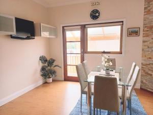 comedor con mesa, sillas y ventana en Ocean Aspect and Central to CBD - CoSheirm Apartments On Merri en Warrnambool