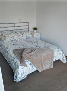 een slaapkamer met een bed met een blauw en wit dekbed bij Beautiful 1 bedroom cottage on 1 acre in Sandford