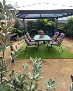 a table and chairs under a black umbrella at Ocean Aspect and Central to CBD - CoSheirm Apartments On Merri in Warrnambool