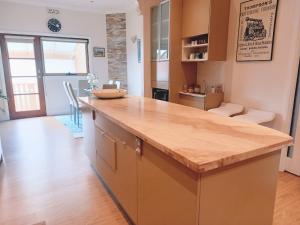 uma cozinha com um balcão de madeira num quarto em Ocean Aspect and Central to CBD - CoSheirm Apartments On Merri em Warrnambool