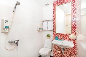 a bathroom with a white toilet and a mirror at Hotel 81 Kovan in Singapore