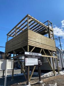 a wooden building on a stand with a sign at Skyhouse2 Kawaguchiko Station in Fujikawaguchiko