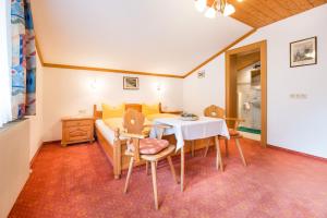 a room with a table and chairs and a bed at Haus Gleinser - Neustift im Stubaital in Neustift im Stubaital