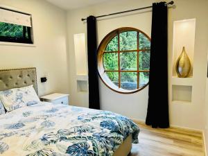 um quarto com uma cama e uma grande janela em Farm Stay POPLAR Cottage at Wilindi Estate em Tyabb
