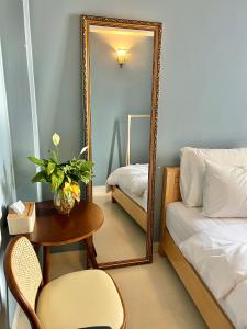 um quarto com um espelho, uma mesa e uma cama em Nhà An Đà Lạt em Da Lat