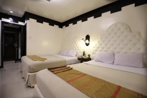 En eller flere senge i et værelse på Camelot Hotel