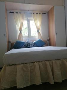 a large bed with blue pillows in front of a window at Room in Guest room - Private room in Boca Chica Resort condominium in Boca Chica