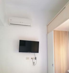 TV de pantalla plana en una pared blanca en una habitación en Room in Guest room - Private room in Boca Chica Resort condominium, en Boca Chica