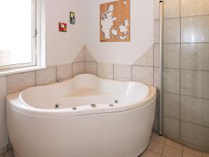 y baño con ducha y bañera blanca. en 6 person holiday home in Hadsund, en Helberskov