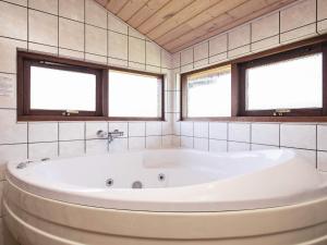 a bath tub in a bathroom with two windows at 8 person holiday home in Fjerritslev in Torup Strand