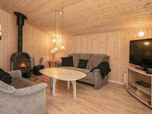 a living room with a couch and a table and a fireplace at 6 person holiday home in Fjerritslev in Fjerritslev