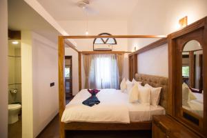 a bedroom with a bed with a robe on it at Dunhill Beach Resort in Agonda