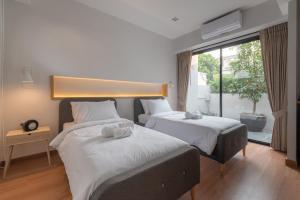 a bedroom with two beds and a large window at Eleven Pillar Site Chiangmai in Chiang Mai