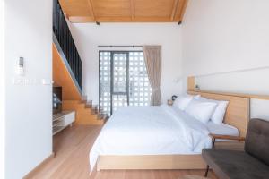 a bedroom with a white bed and a staircase at Eleven Pillar Site Chiangmai in Chiang Mai