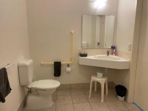 a bathroom with a toilet and a sink at Ascot Motor Lodge in Wellington