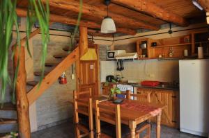 a kitchen with a wooden table and a wooden staircase at Carpe Diem Cabañas & Suites in El Bolsón