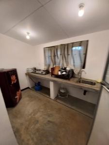 Habitación con encimera, lavabo y ventana en Abinu"s Place en Dikwella South