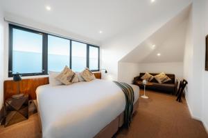 1 dormitorio con 1 cama blanca grande y 1 sofá en Cremorne Point Manor, en Sídney