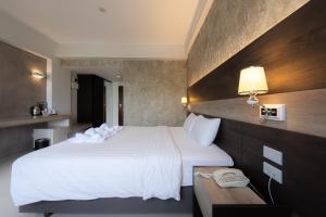 Un pat sau paturi într-o cameră la The Proud Exclusive Hotel-SHA Plus
