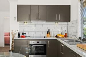 a kitchen with gray cabinets and a counter top at Casa Capri - Aldinga Beach - C21 SouthCoast Holidays in Aldinga Beach