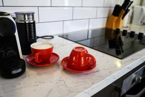 a cup of coffee sitting on a counter next to a coffee maker at Casa Capri - Aldinga Beach - C21 SouthCoast Holidays in Aldinga Beach