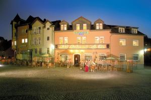 een groot gebouw met mensen die ervoor staan bij Ringhotel Lutherhotel Eisenacher Hof in Eisenach