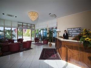 a woman standing at a counter in a lobby at Hotel Riviera Lido in Milazzo