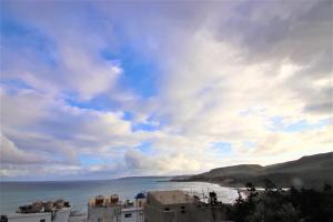 a view of a beach with buildings and a cloudy sky at Kenting Afei Surf Hostel Jialeshuel Nanu in Manzhou