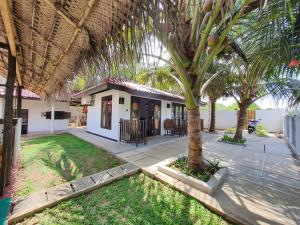 una casa con una palmera en el patio en kingfish villa and restaurant, en Ranna