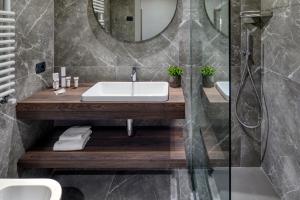 a bathroom with a sink and a mirror at Porta Altinia Suites in Treviso +41 photos