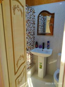 a small bathroom with a sink and a mirror at Family Guest house - Friends-J in Nukus