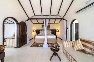 a bedroom with a bed and a couch at PrideInn Flamingo Beach Resort & Spa Mombasa in Mombasa